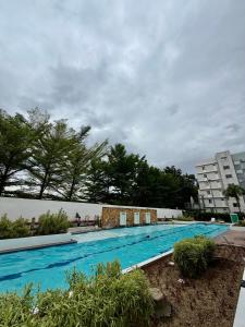 a large blue swimming pool with trees and a building at 8 Spatial Condo in Davao City