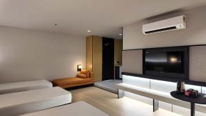 a living room with a couch and a tv at Urban Inn, Alor Setar in Alor Setar