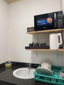 a kitchen counter with a sink and a tv on a shelf at Lemon Inn in Ko Lanta