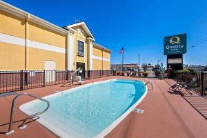 a swimming pool in front of a building at Quality Inn Alexander City in Alexander City