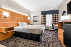 a hotel room with a bed and a desk at Quality Inn Alexander City in Alexander City +25 photos