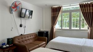 a hotel room with a bed and a chair and a window at KHÁCH SẠN ROMO in Quảng Ngãi