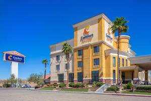 a yellow hotel with a sign on the front of it at Comfort Suites Barstow near I-15 in Barstow