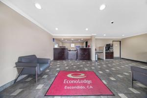 an office lobby with a red welcome rug on the floor at Econo Lodge Inn & Suites Escondido Downtown in Escondido +20 photos