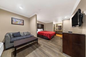a hotel room with a couch and a bed at Econo Lodge Inn & Suites Escondido Downtown in Escondido