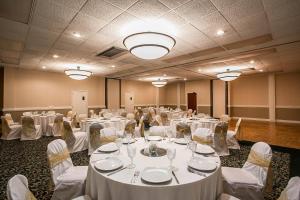 a room filled with tables and chairs with white linens at Quality Inn Sumter near Shaw AFB in Sumter +62 photos