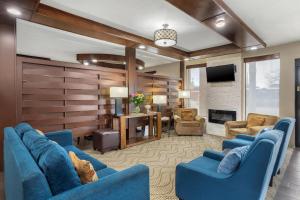 a living room with blue furniture and a fireplace at Comfort Suites Brenham in Brenham
