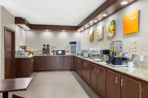 a large kitchen with wooden cabinets and a counter at Comfort Suites Brenham in Brenham