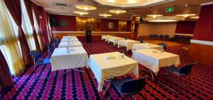 a dining room with white tables and chairs at OrientalPalace Hotel in Manama