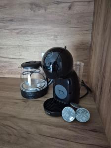 a black coffee maker sitting on a table with coins at Ilma Apartmani Musique in Tuzla