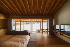 a bedroom with a large bed and a table with chairs at ヴィラブラマーレ in Kitahiroshima
