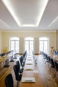 a large room with long tables and chairs at Hotel Schloss & Gut Ulrichshusen in Ulrichshusen