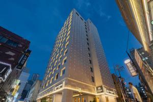 a tall building in the middle of a city at H-AVENUE Hotel Yeongdeungpo in Seoul