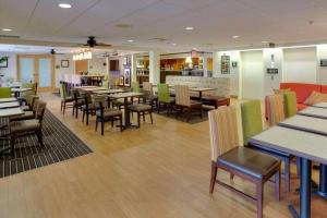 a dining room with tables and chairs in a restaurant at Pittsburgh Airport Inn and Suites in Coraopolis