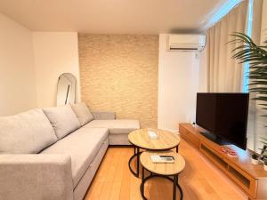 a living room with a couch and a flat screen tv at Franmare in Okayama