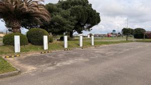 a parking lot with white posts on the side of a road at Campanile Marmande in Marmande