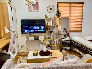 a living room with a couch and a tv at Olango Island-Tiny Guest House Fully Furnished with Hot Shower, Washer, Wi-Fi, Netflix & King Bed S&E-3 in Lapu Lapu City