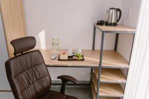 a desk with a chair next to a table with a coffee maker at SmartCity Hometel in Can Tho