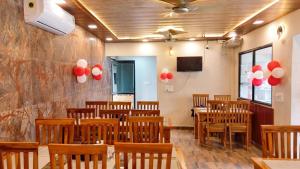 a room with wooden chairs and red and white balloons at Corbett Hill Site in Rāmnagar