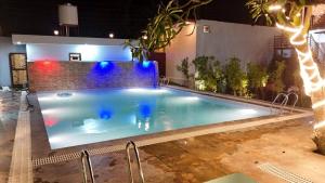 a large swimming pool with blue lights on it at Corbett Hill Site in Rāmnagar