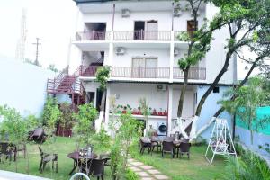 a hotel with tables and chairs in front of a building at Corbett Hill Site in Rāmnagar