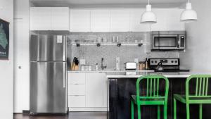 a kitchen with green chairs and a stainless steel refrigerator at The Sobro Guest House by AvantStay in Nashville
