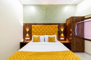 a bedroom with a large white bed with yellow pillows at Imperial Hotel Near Haji Ali in Mumbai