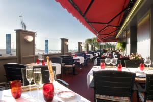 a restaurant with tables and chairs with a view at Hotel De La Matelote in Boulogne-sur-Mer