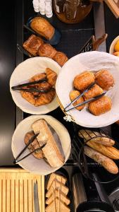 a bunch of plates filled with bread and pastries at Campanile Marmande in Marmande