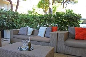 two wicker chairs and a bottle of wine on a table at Hotel New Primula in Rimini