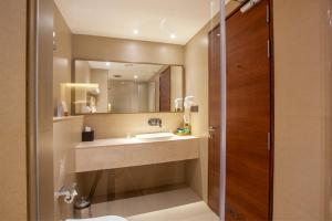 a bathroom with a sink and a mirror at Purple Elephant Luxury Business Hotel in Cochin