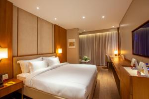 a hotel room with a large bed and a desk at Purple Elephant Luxury Business Hotel in Cochin