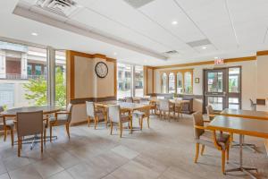 a dining room with tables and chairs and a clock at Quality Hotel Fallsview Cascade in Niagara Falls