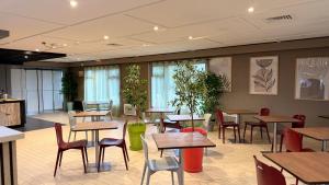 a restaurant with tables and chairs and plants at Campanile Marmande in Marmande +15 photos
