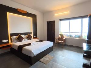 a bedroom with a large bed and a balcony at Rock And Mist Munnar House Resort in Munnar