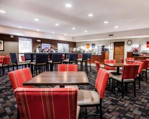 a restaurant with tables and chairs and a bar at Comfort Suites Independence - Kansas City in Independence