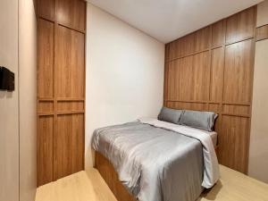 a bedroom with a bed and wooden cabinets at Hendi Homestay E No 8 Puriloka1 in Batam Center +9 photos