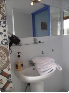 a bathroom with a sink and a mirror and towels at Ellenas- studios Nikiana Lefkada in Nikiana