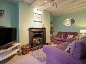 a living room with a purple couch and a fireplace at Preswylfa in Blaenau-Ffestiniog