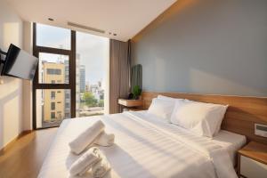 a bedroom with a large bed with towels on it at Anora Home by BRIO in Danang