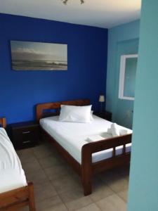 a bedroom with a blue wall and a bed at Ellenas- studios Nikiana Lefkada in Nikiana