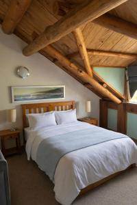 a bedroom with a large white bed with wooden ceilings at Yallingup Surfing wineries and restaurants in Yallingup