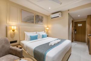 a hotel room with a large bed and a chair at Monday Premium Madhapur in Hyderabad +34 photos