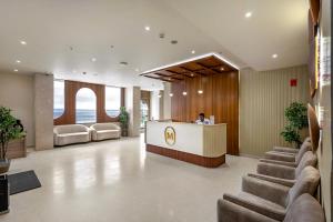 a man sitting at a reception desk in a hotel lobby at Monday Premium Madhapur in Hyderabad