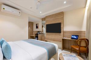 a hotel room with a bed and a flat screen tv at Monday Premium Madhapur in Hyderabad