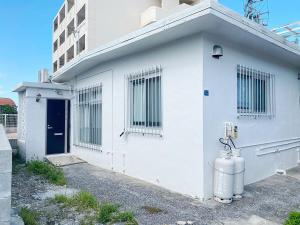 a white building with a fire hydrant in front of it at 外人住宅ーアメリカンビレッジ車20分 in Urazoe