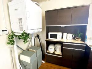 a kitchen with a microwave oven and a counter top at 外人住宅ーアメリカンビレッジ車20分 in Urazoe +42 photos