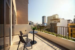a balcony with two chairs and a table on a building at Anora Home by BRIO in Danang