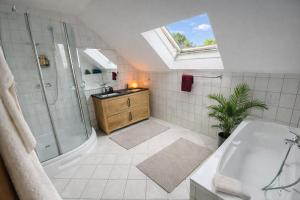 a bathroom with a shower and a tub and a sink at Ferienhaus ,,Pier 7" am See - 2 Wohnungen mit Garten für bis zu 11 Personen, einzeln oder zusammen buchbar in Große Mühle