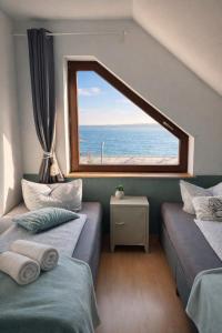 a room with two beds and a large window at Ferienhaus ,,Pier 7" am See - 2 Wohnungen mit Garten für bis zu 11 Personen, einzeln oder zusammen buchbar in Große Mühle